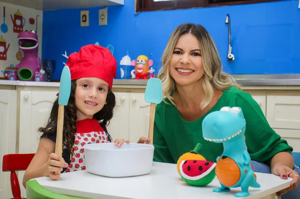 Silvicleide em atendimento lúdico com uma criança, com frutas e brinquedos à mesa